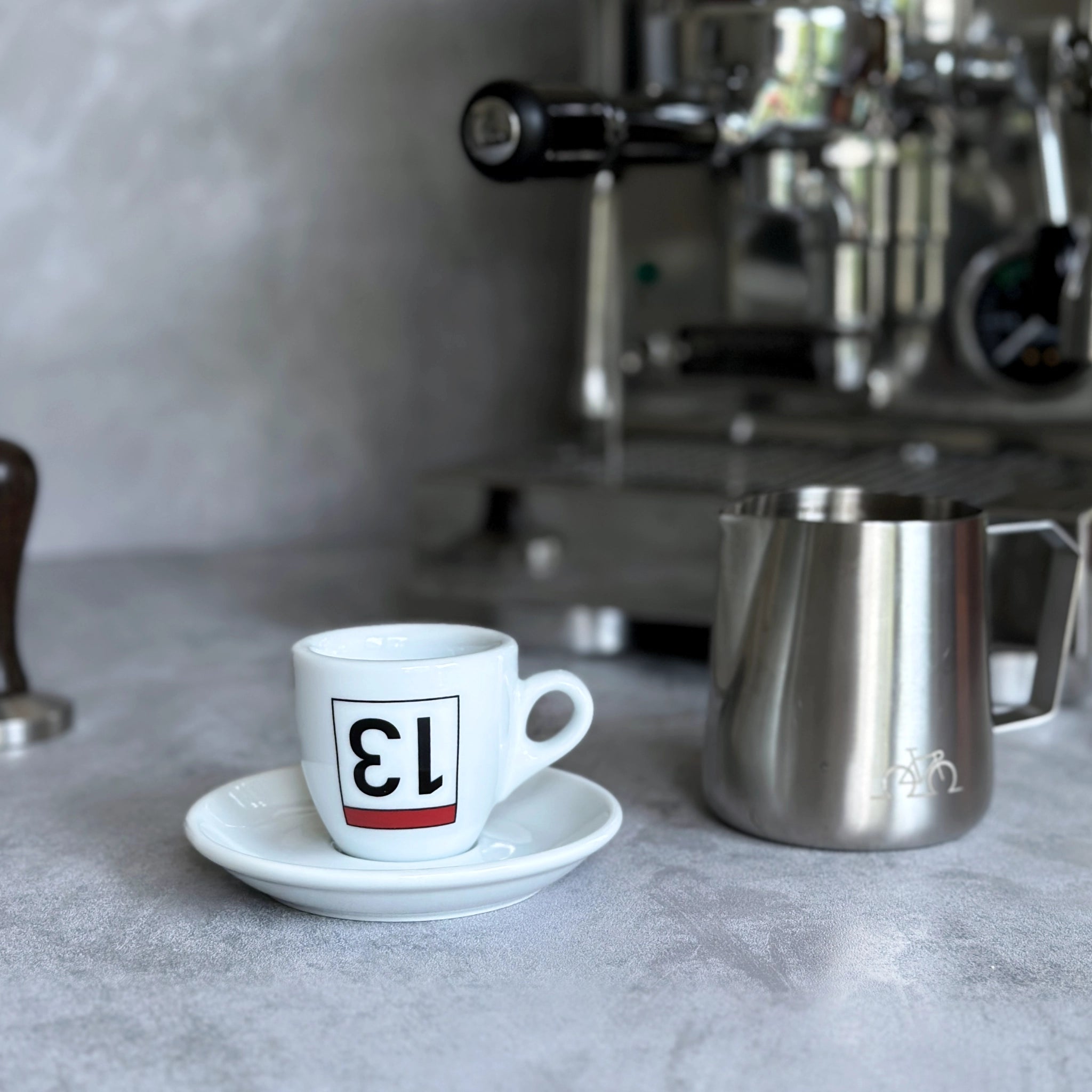 Espresso-Tasse mit Radsport-Print Lucky 13 vor Siebträgermaschine