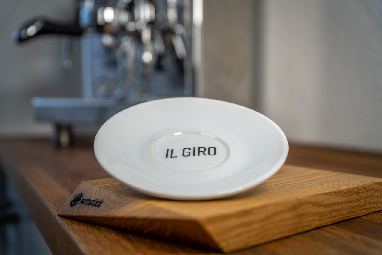 Eine weiße Untertasse mit dem Schriftzug „Il Giro“