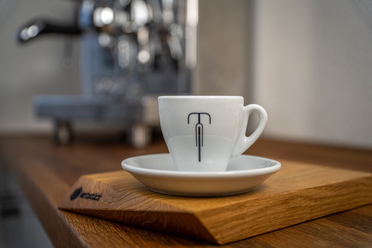 Eine weiße Espresso-Tasse mit einem stilisierten Rennrad.