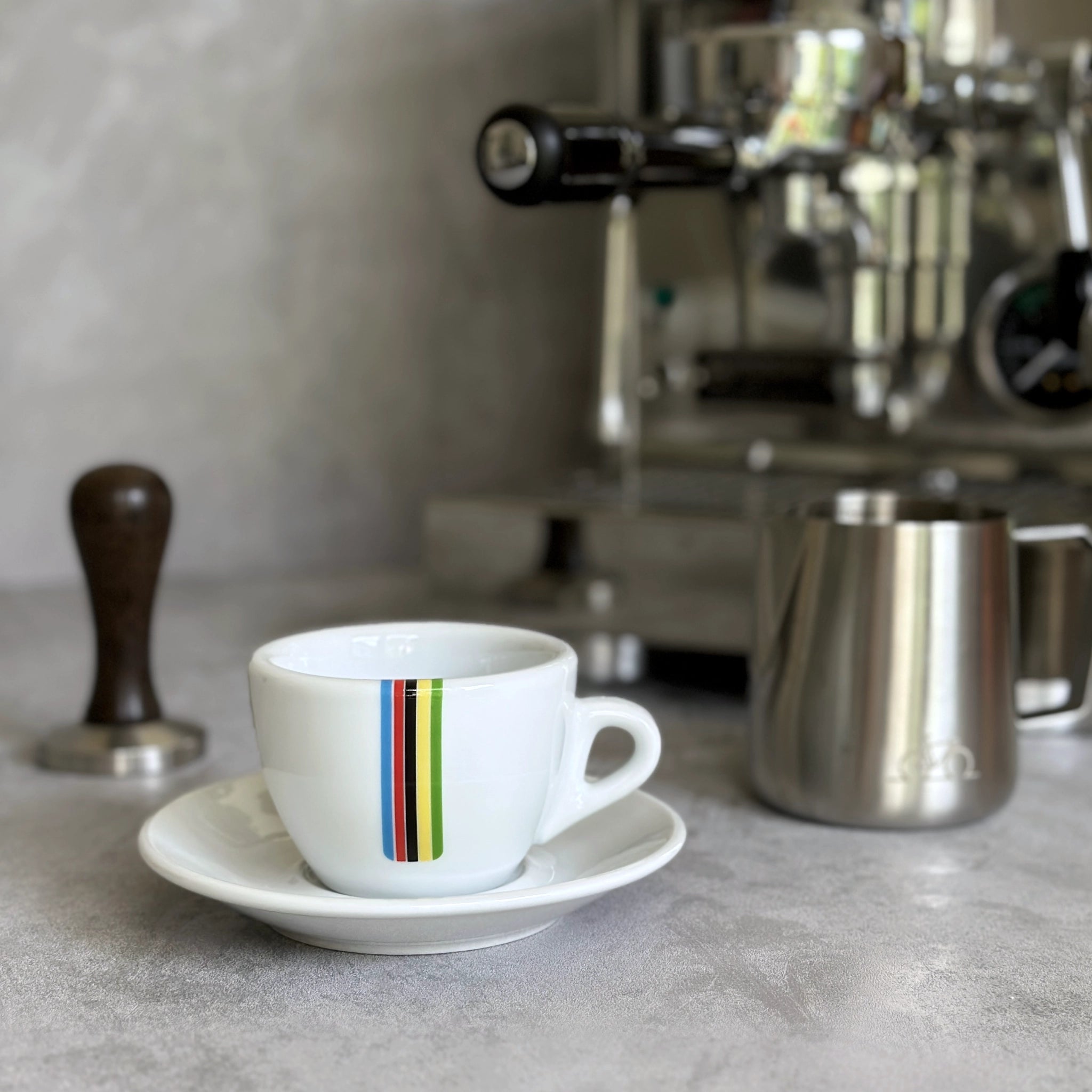 Cappuccino-Tasse mit Radsport-Print Rainbow-Streifen vor Siebträgermaschine