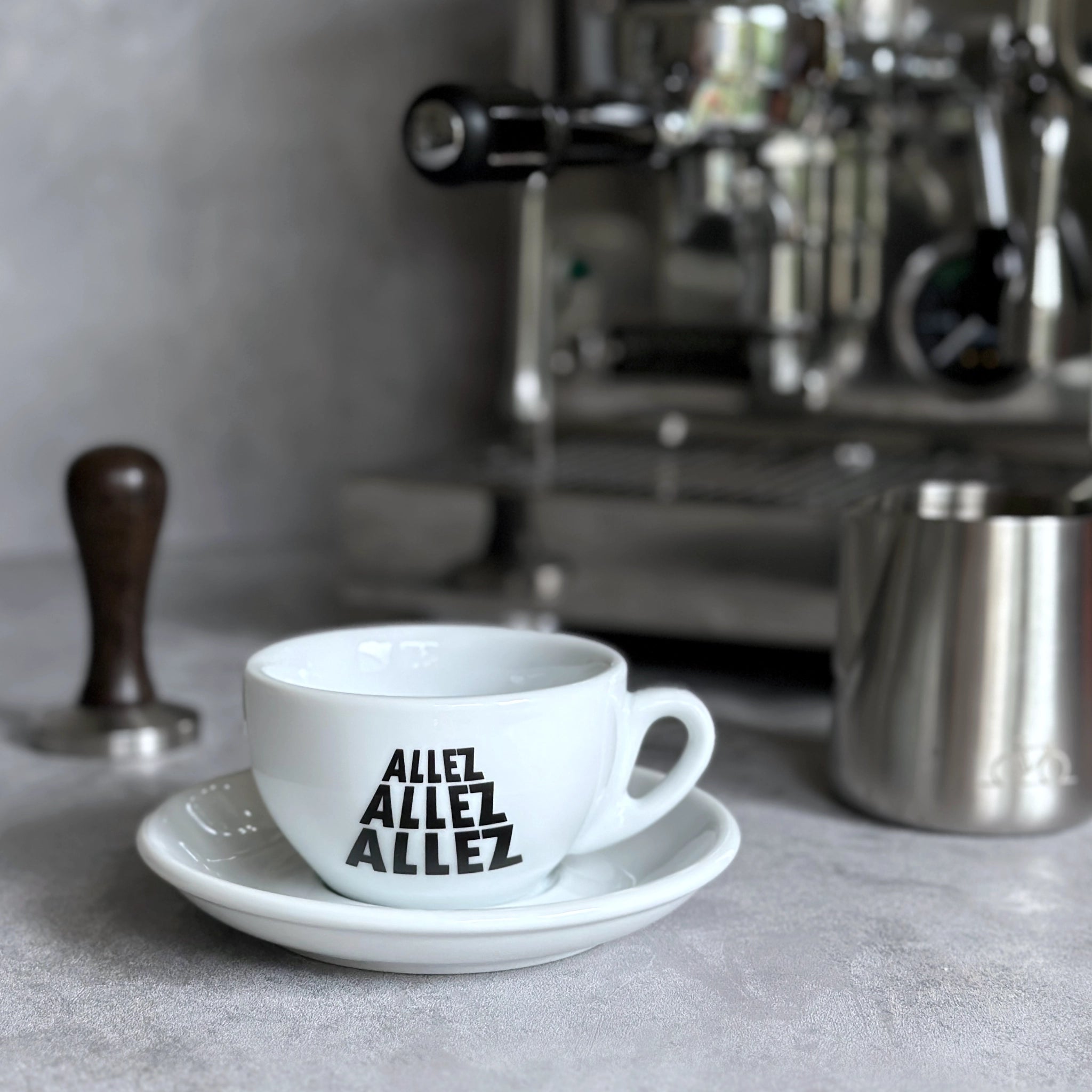 Cappuccino Grande Tasse mit Radsport-Slogan Allez Allez Allez vor Siebträgermaschine