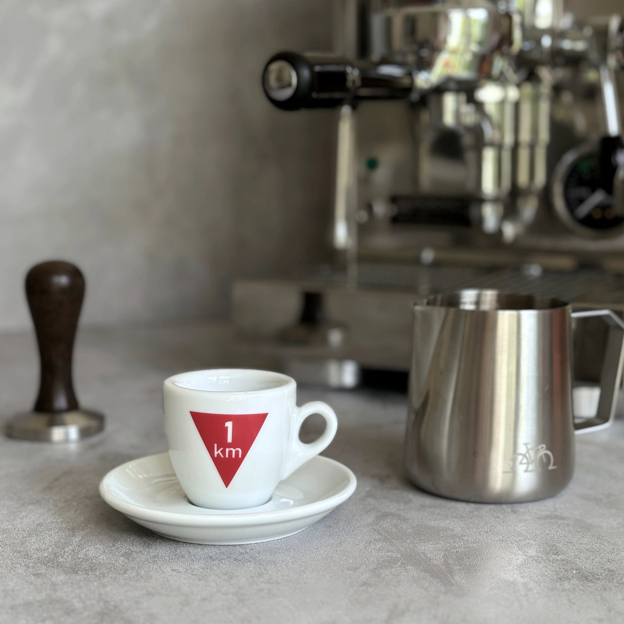 Espresso-Tasse mit Radsport-Motiv  Flamme Rouge vor Siebträgermaschine