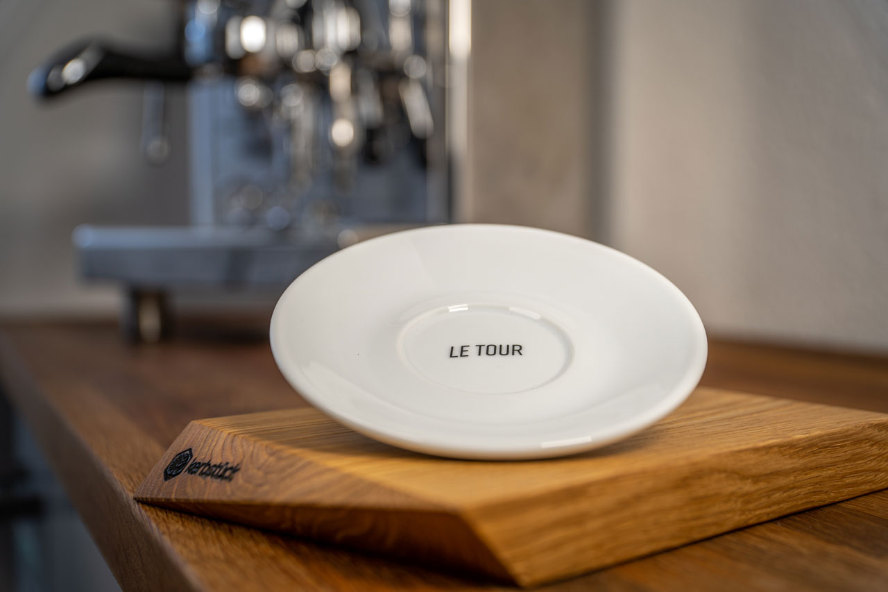 Eine weiße Untertasse mit dem Schriftzug „Le Tour"